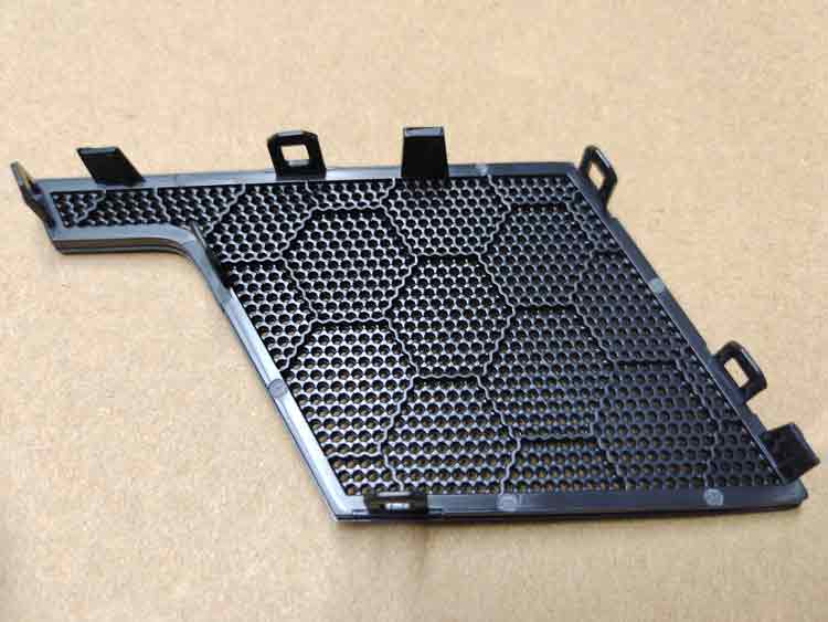 Back side of complex-shaped ABS plastic speaker cover showing support ribs and ejection pin marks