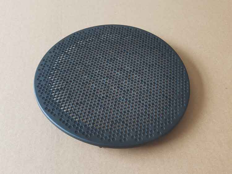 Front side of a round plastic speaker cover made from PP, showing fine perforated holes with smooth edges