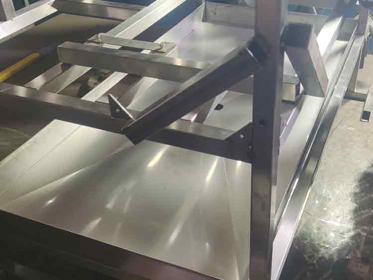 Stainless steel tray being welded into place, showing the alignment with the frame for a secure fit.