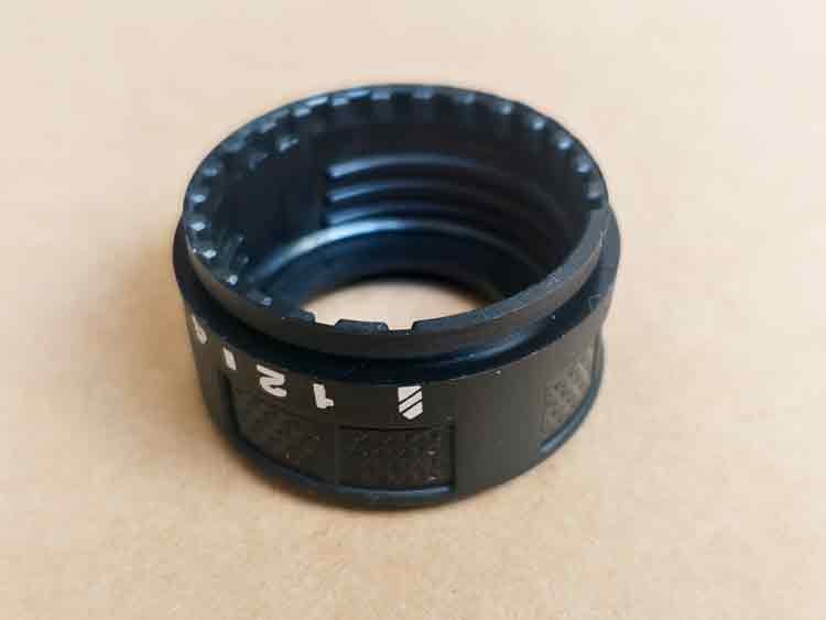 Primer plano de la superficie interior de un pomo de ajuste de plástico, en el que destacan las roscas intermitentes diseñadas para la alineación del posicionamiento.