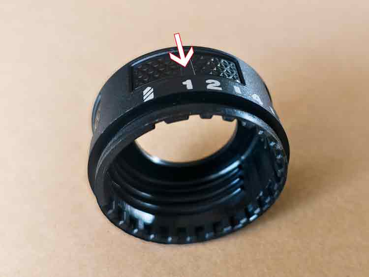 Close-up view showing the alignment of printed number "1" with the inner groove on the plastic adjustment knob.