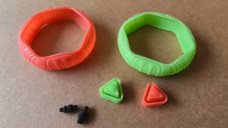 Silicone components from a custom plastic toy including two colorful sleeves and small triangular inserts made through compression molding.