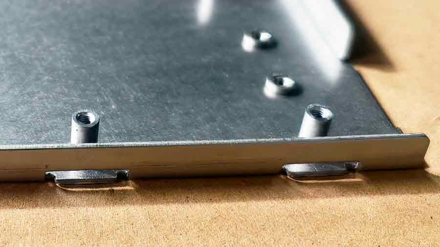 Gros plan du relief de pliage sur une pièce d'emboutissage personnalisée, montrant la zone plate sous la fente de relief, sans pliage dans cette section.