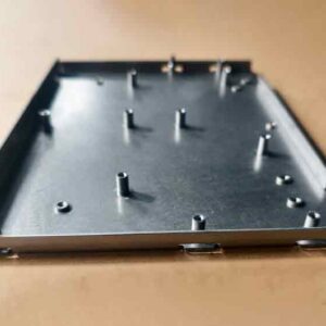 Seitliche Vorderansicht eines kundenspezifischen Stanzteils mit selbstsichernden Muttern, die einen besseren Blick auf die Form und das Design ermöglicht.