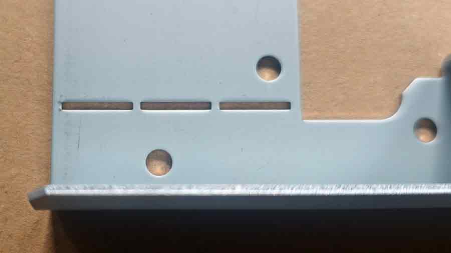 Gros plan d'une pièce découpée sur mesure montrant le faible espacement entre les trous rectangulaires, seulement 1,5 mm, égal à l'épaisseur du matériau.