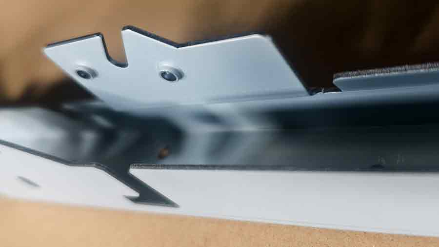 Gros plan d'une pièce d'emboutissage personnalisée montrant le trou fraisé détaillé, conçu pour des vis encastrées.