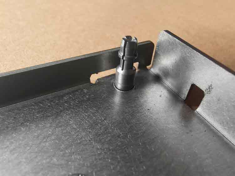 Vue rapprochée de l'encliquetage sur la pièce d'emboutissage personnalisée, montrant sa conception et sa fonction dans un assemblage.